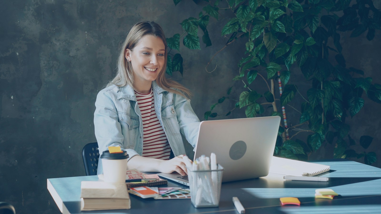 Una persona sonriendo frente a una laptop